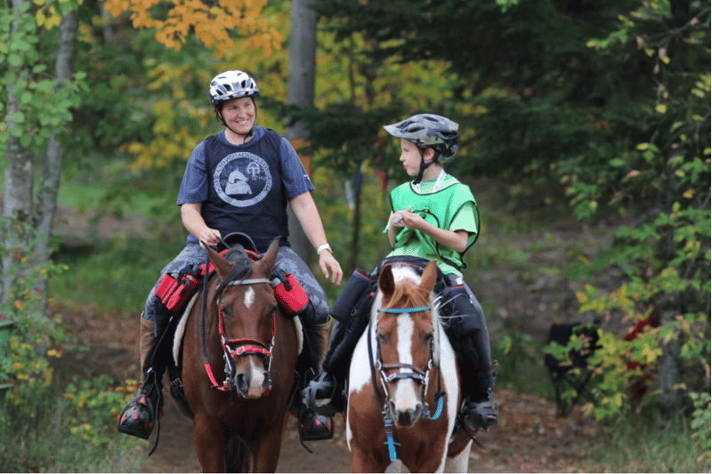 endurance horse rider and junior rider on trail